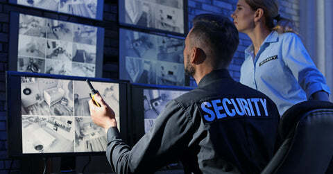 Two security guards keeping watch on cameras