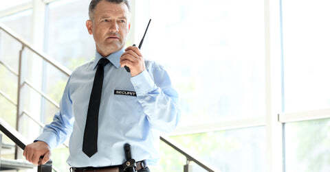 Security guard holding walkie talkie on a stairway