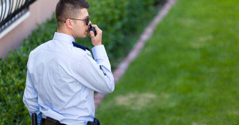 Security guard on patrol taking into a walkie talkie