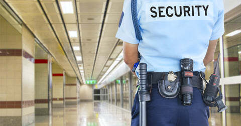 Security guard with belt surveilling a hallway
