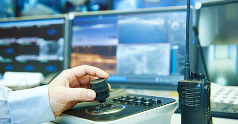 Security guard hand on camera operation in surveillance room